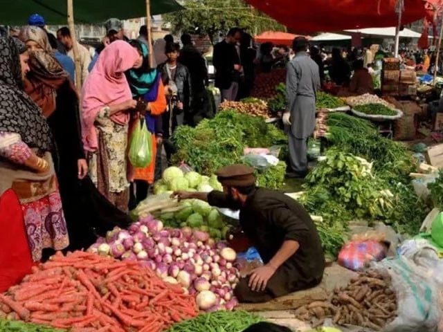 Lahore vegetable market where retail prices for tomatoes, onions, and garlic significantly exceed official rates.