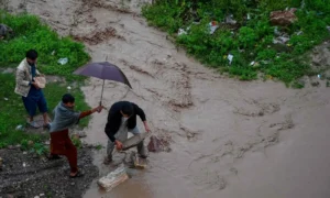 Rescue personnel evacuate residents from flooded Sardar Colony in Peshawar as Budhni nullah reaches high flood level