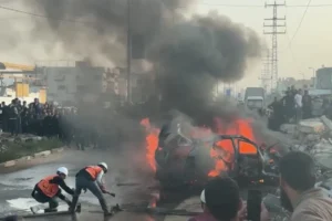 Emergency workers at the site of an Israeli strike on a civilian vehicle on Salah al-Din Street in central Gaza, which killed one person.