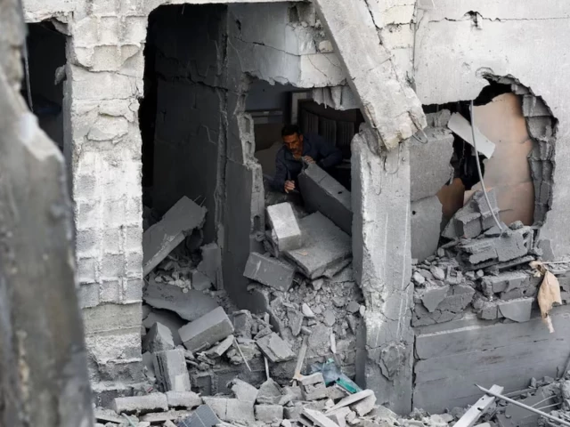 Rescue workers and civilians inspecting damage after an Israeli airstrike hit a residential apartment building in Gaza City.