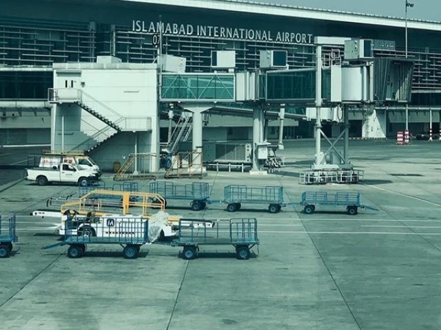 FIA immigration officers screening international passengers at a Pakistani airport as part of anti-human trafficking operations.