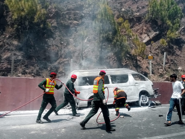 Burnt passenger van at the accident site on the Rawalpindi–Murree Expressway as rescue teams conduct recovery operations.